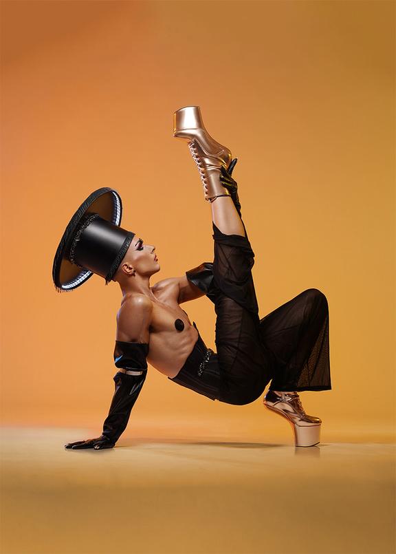 Majestic Luxor posiert in einem High-Fashion-Kostüm in einer extravaganten Pose.