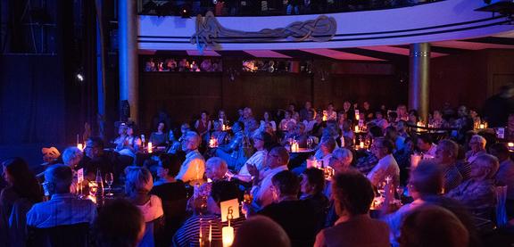 Publikum im dämmrig beleuchteten Varietésaal.