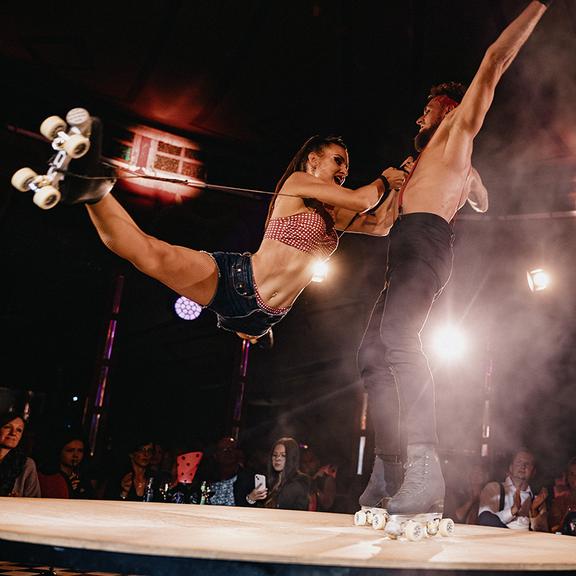 Duo Rock’n’Roller bei einer Rollkunstlaufnummer: Volodymyr dreht sich, Alyona hängt im Spagat an seinem Hals.t