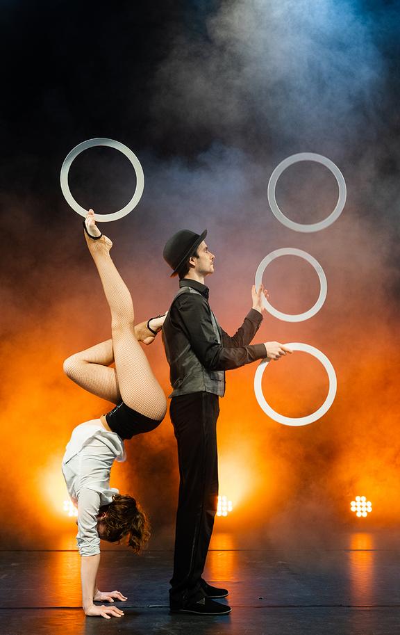 Duo Fontanella führt eine Reifen-Jonglage auf, eine Artistin ist dabei im Handstand.