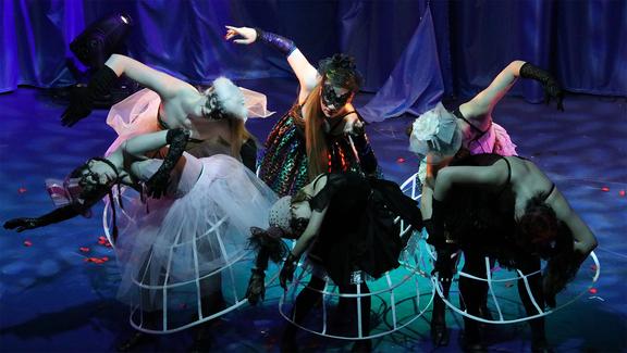 TänzerInnen der Kinderrevue tanzen im Kostüm auf einer Bühne.